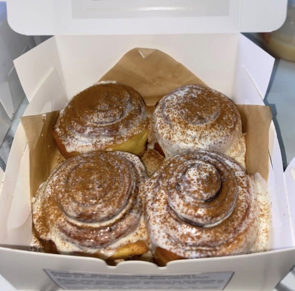 Box of four agst. cinnamon rolls with cream cheese frosting and cinnamon dust